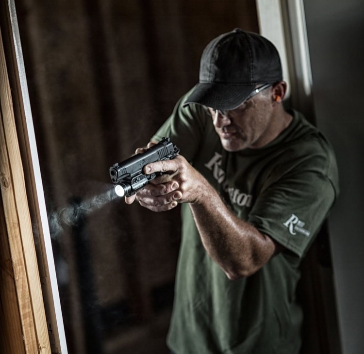 ハンドガンにライトを装着して構える様子