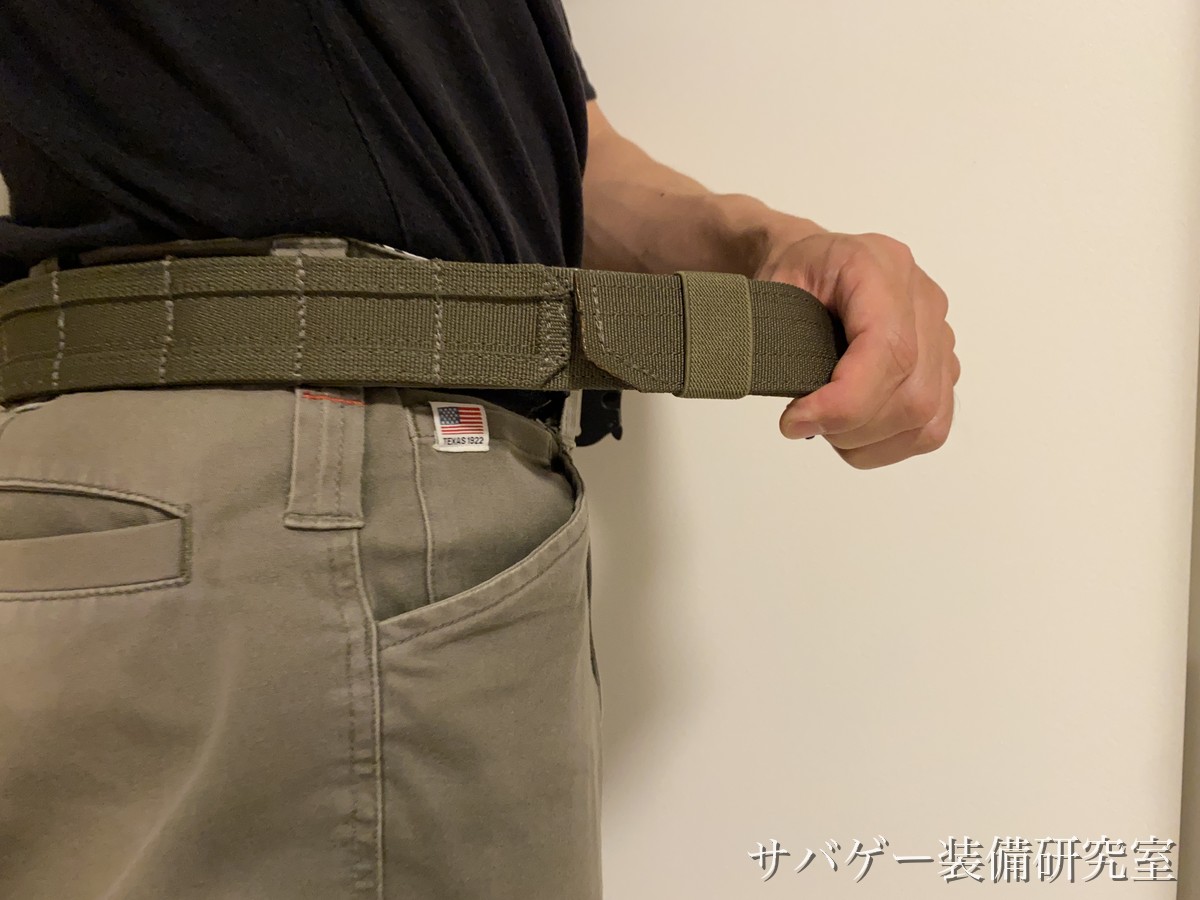 アウターベルトの端を引いて締め具合を調整しているところ